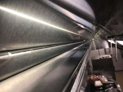 clean hood tracks in commercial kitchen